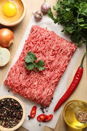 Photo of Raw ground meat and different products on table, flat lay