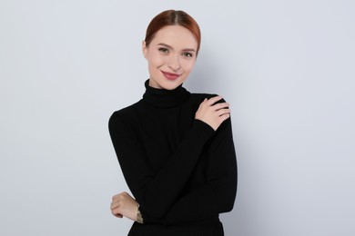 Portrait of beautiful young woman on light gray background