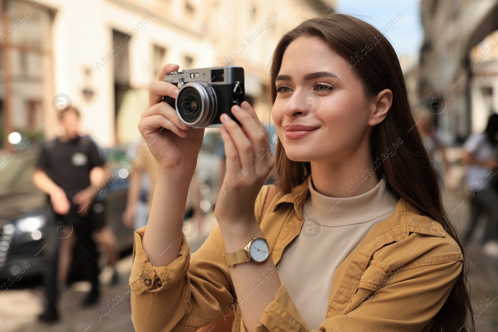 Photo of Young woman with camera taking photo on city street. Interesting hobby