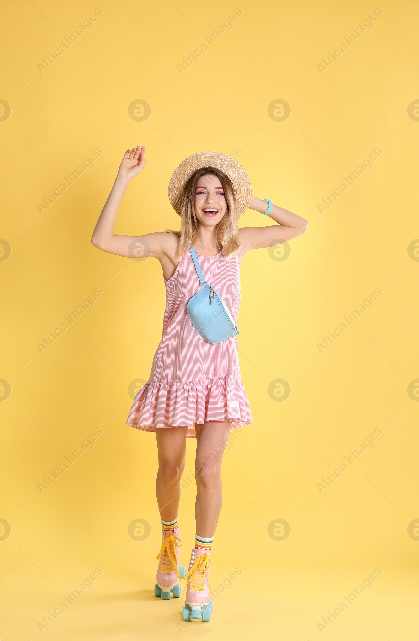 Photo of Young woman with retro roller skates on color background