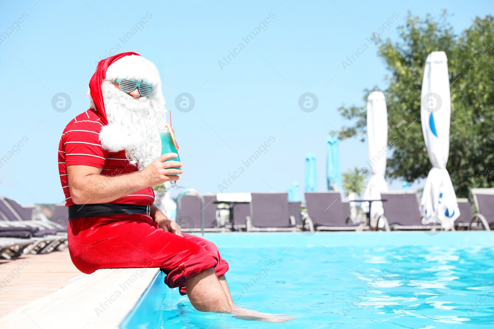 Photo of Authentic Santa Claus with cocktail near pool at resort