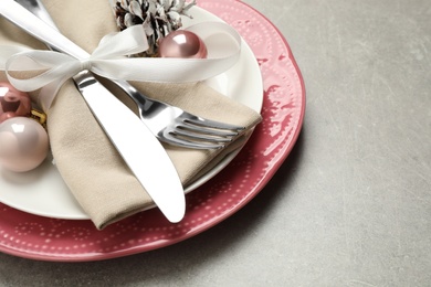 Photo of Festive table setting with beautiful dishware and Christmas decor on grey background, closeup