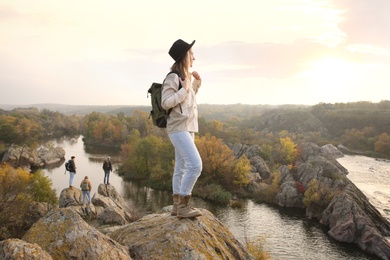 Photo of Woman with backpack enjoying beautiful view near mountain river