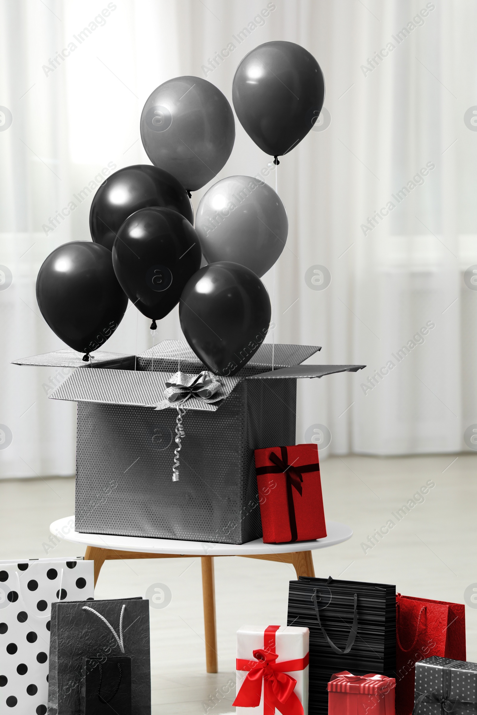 Image of Black Friday concept. Bunch of balloons and shopping bags indoors
