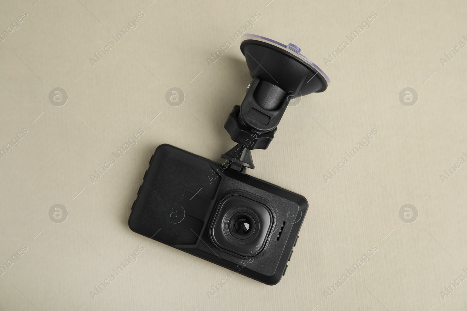 Photo of Modern car dashboard camera with suction mount on light background, top view