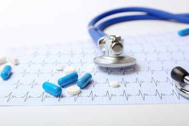 Stethoscope, cardiogram and pills on table. Cardiology service