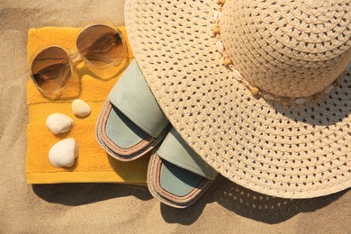Photo of Beach accessories and seashells on sand, top view