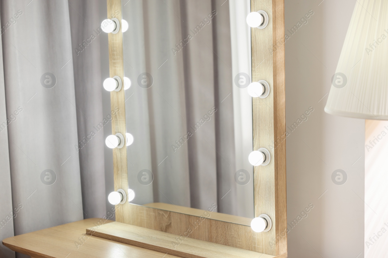 Photo of Beautiful mirror with light bulbs in makeup room