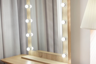 Photo of Beautiful mirror with light bulbs in makeup room