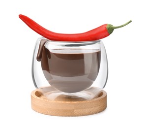Photo of Glass of hot chocolate with chili pepper on white background