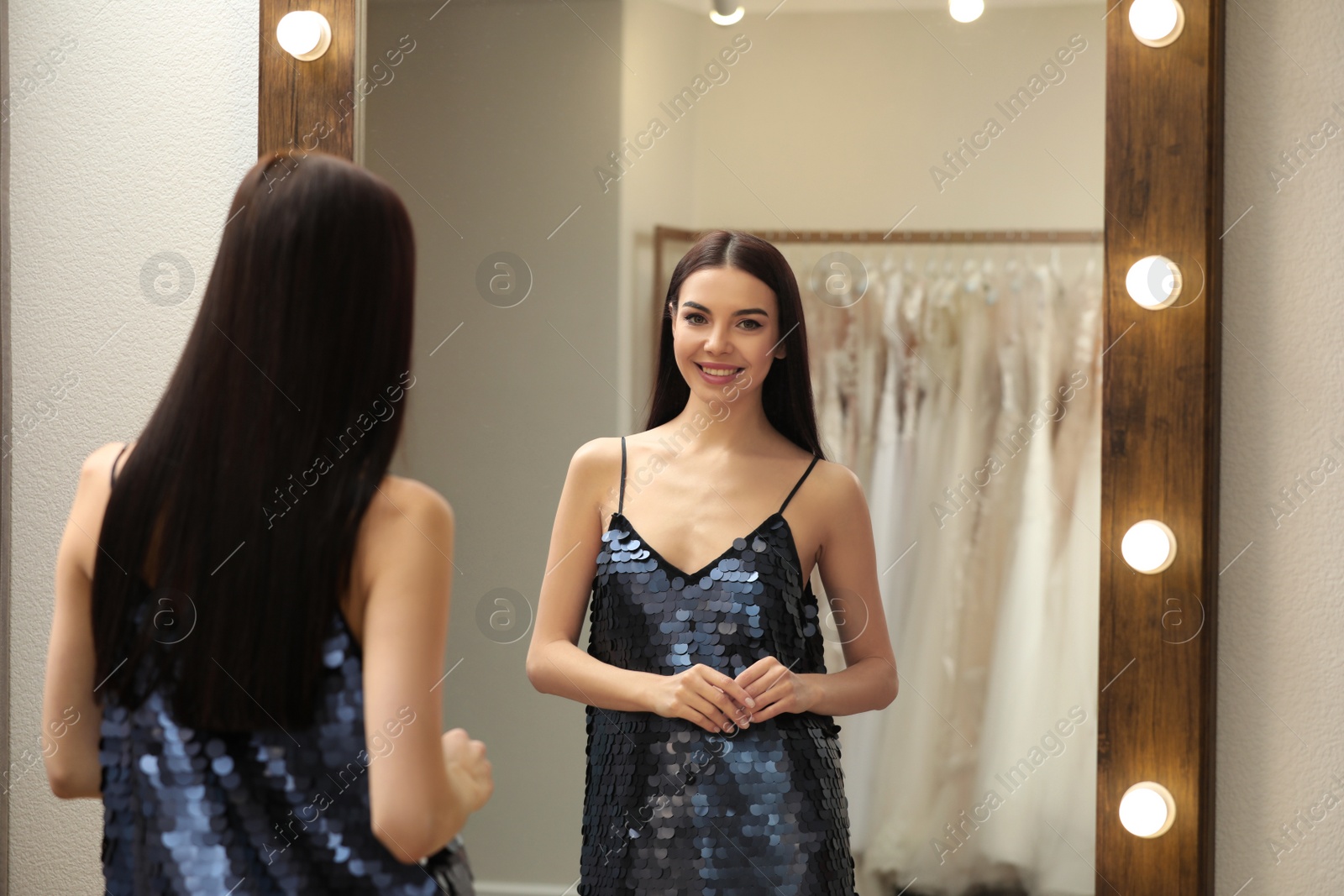 Photo of Woman trying on dress in clothing rental salon