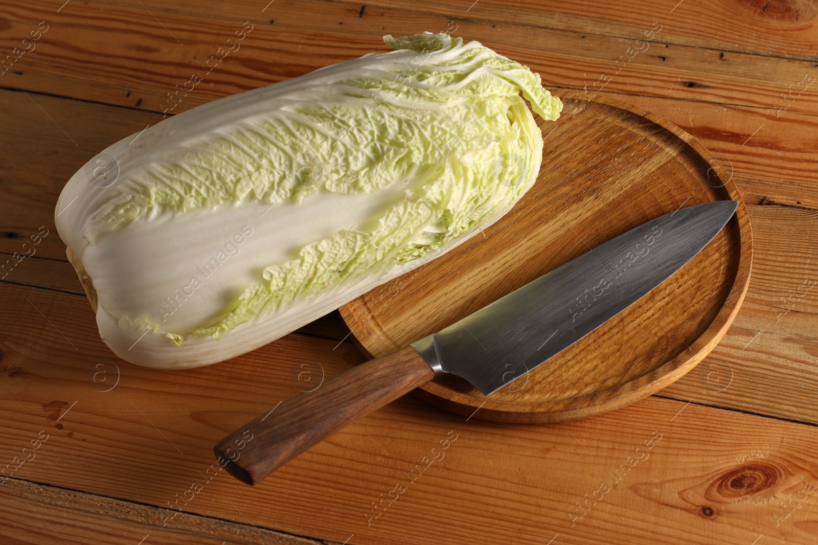 Photo of Fresh Chinese cabbage and knife on wooden table