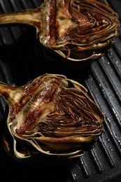 Pan with tasty grilled artichokes, closeup view