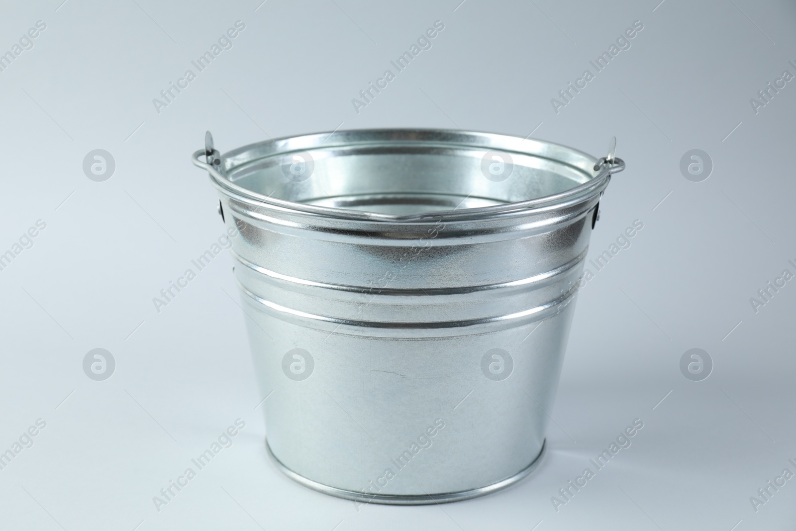 Photo of One shiny metal bucket on white background