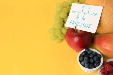 Photo of Card with word Fructose, delicious ripe fruits and berries on yellow background, space for text