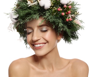 Happy young woman wearing wreath on white background