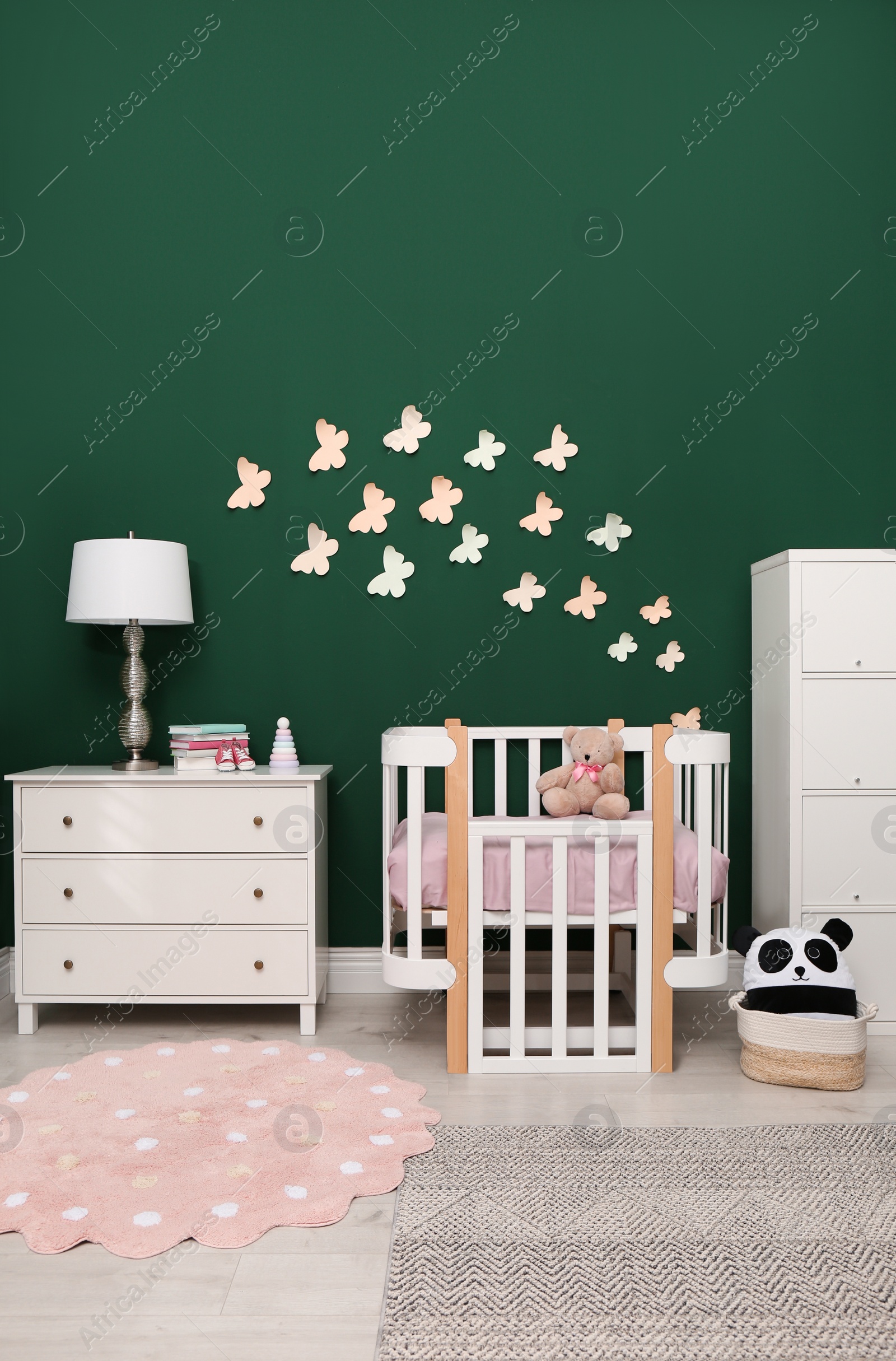 Photo of Beautiful baby room interior with stylish furniture and comfortable crib