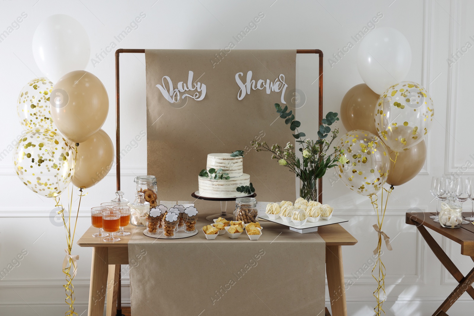 Photo of Beautiful cake and other treats on table in room. Baby shower party