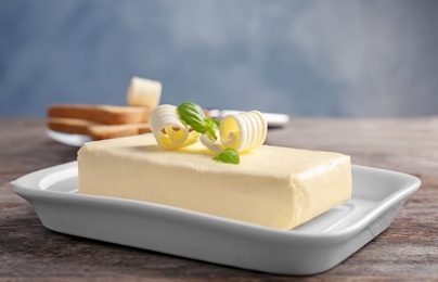 Photo of Dish with butter and curls on table