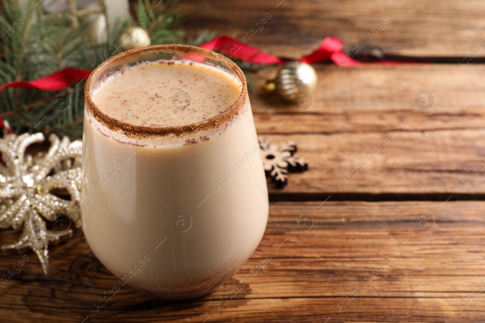 Photo of Delicious Christmas liqueur on wooden table, closeup. Space for text