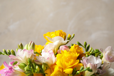 Photo of Beautiful blooming freesias against grey background, closeup. Space for text