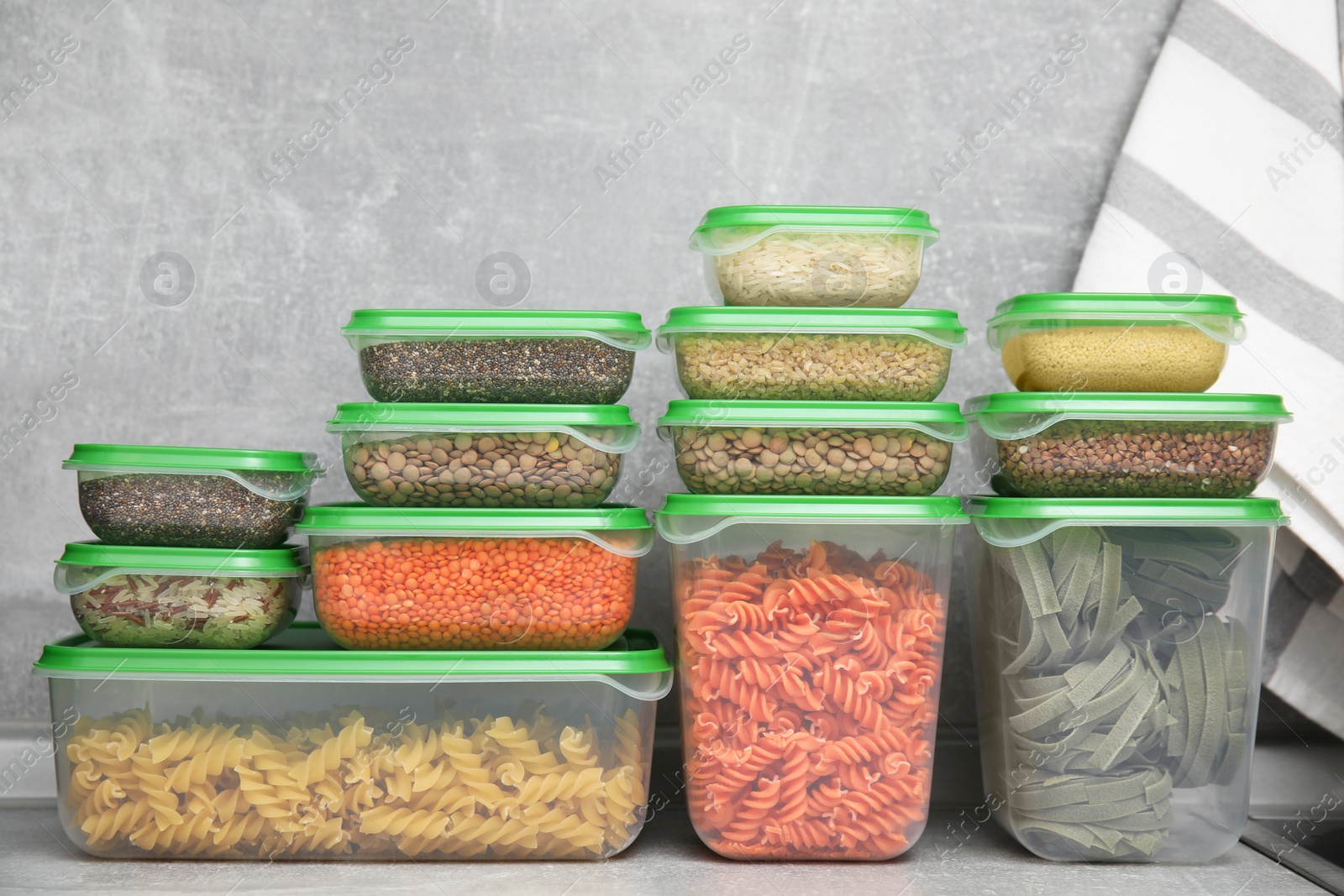 Photo of Plastic containers filled with food products on grey table