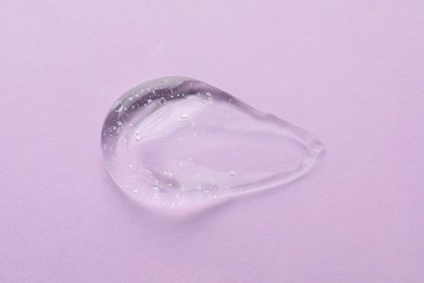 Photo of Clear cosmetic gel on light violet background, top view