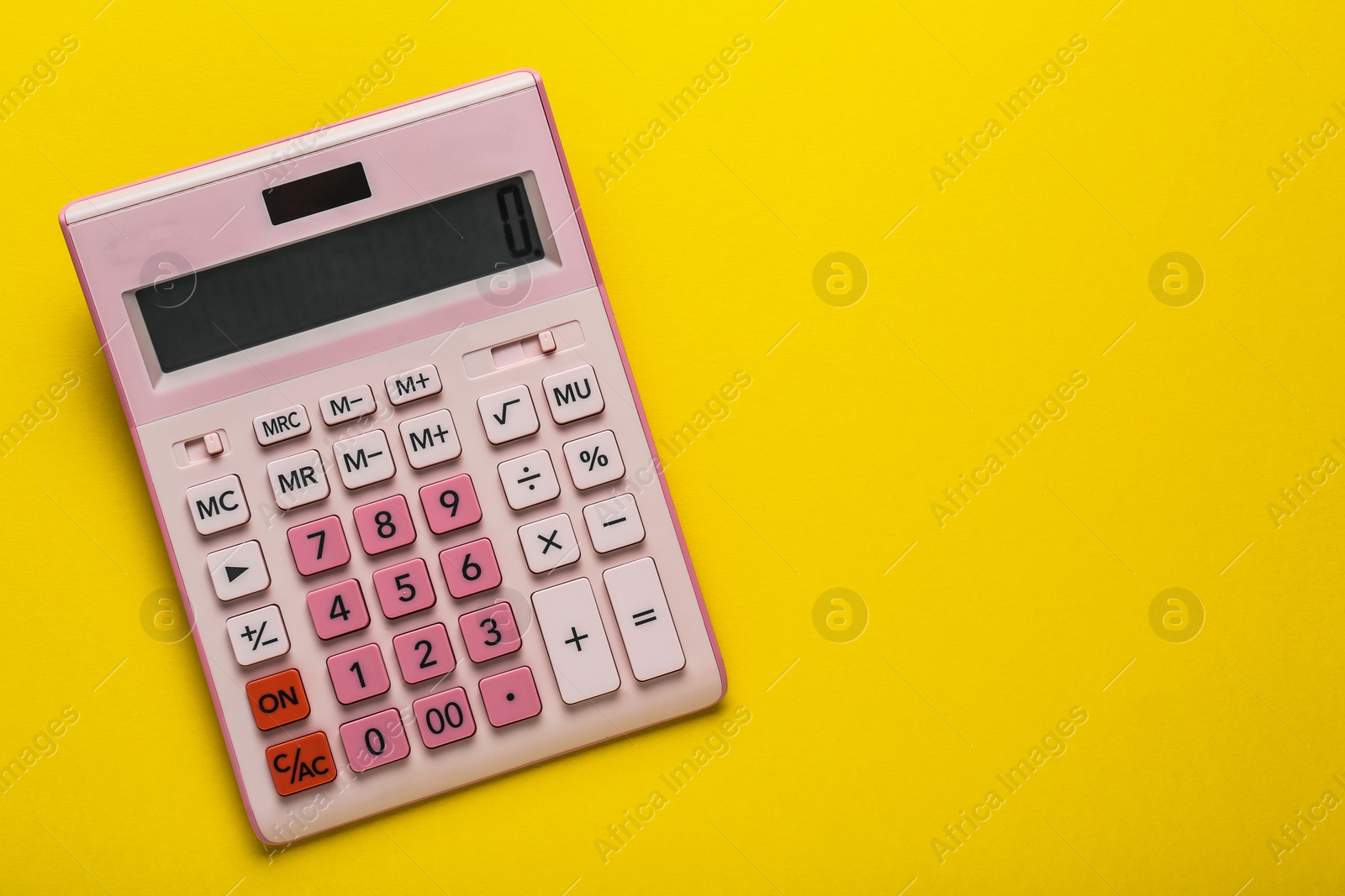 Photo of Pink calculator on yellow background, top view. Space for text