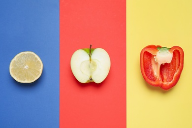 Cut apple, lemon and bell pepper on color background, flat lay