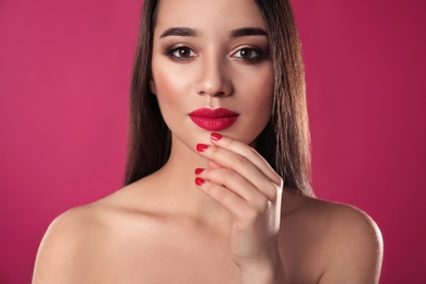 Photo of Beautiful woman with stylish nail polish on color background