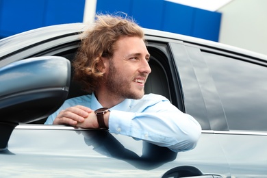 Photo of Attractive young man in his luxury car