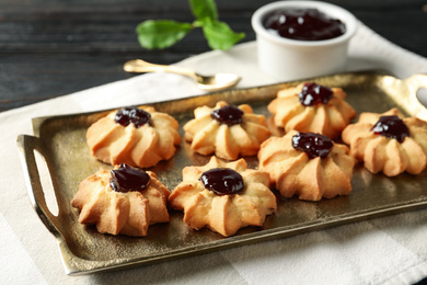 Photo of Tasty shortbread cookies with jam on table