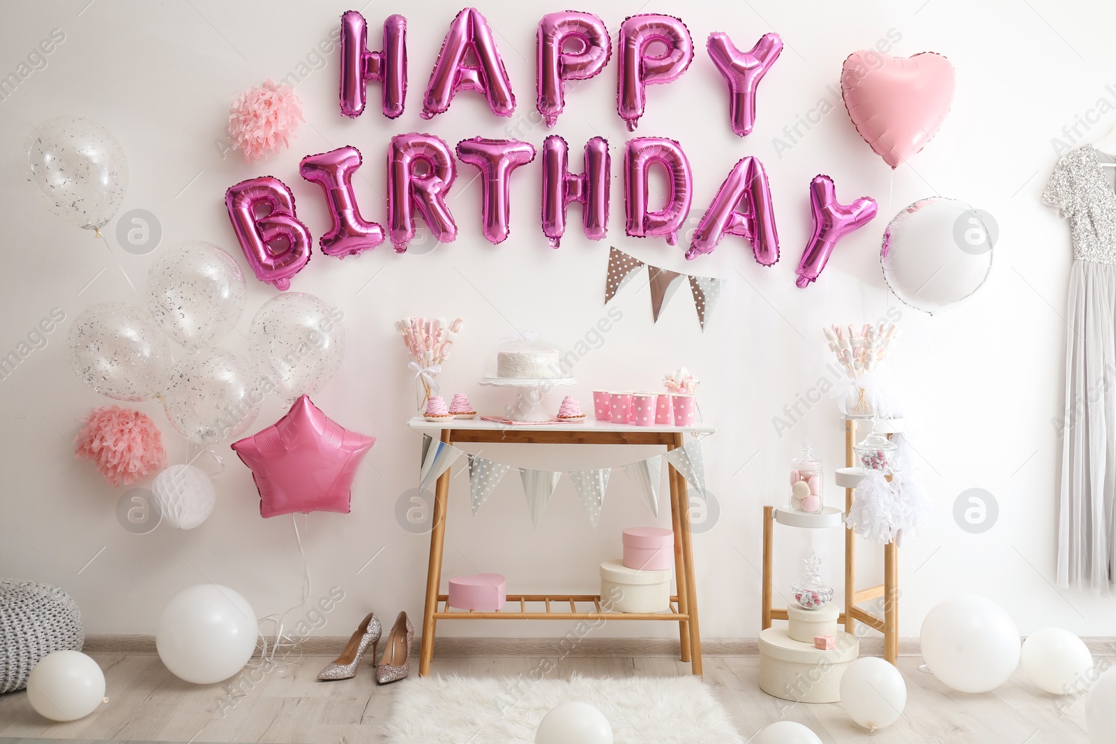 Photo of Phrase HAPPY BIRTHDAY made of pink balloon letters in decorated room