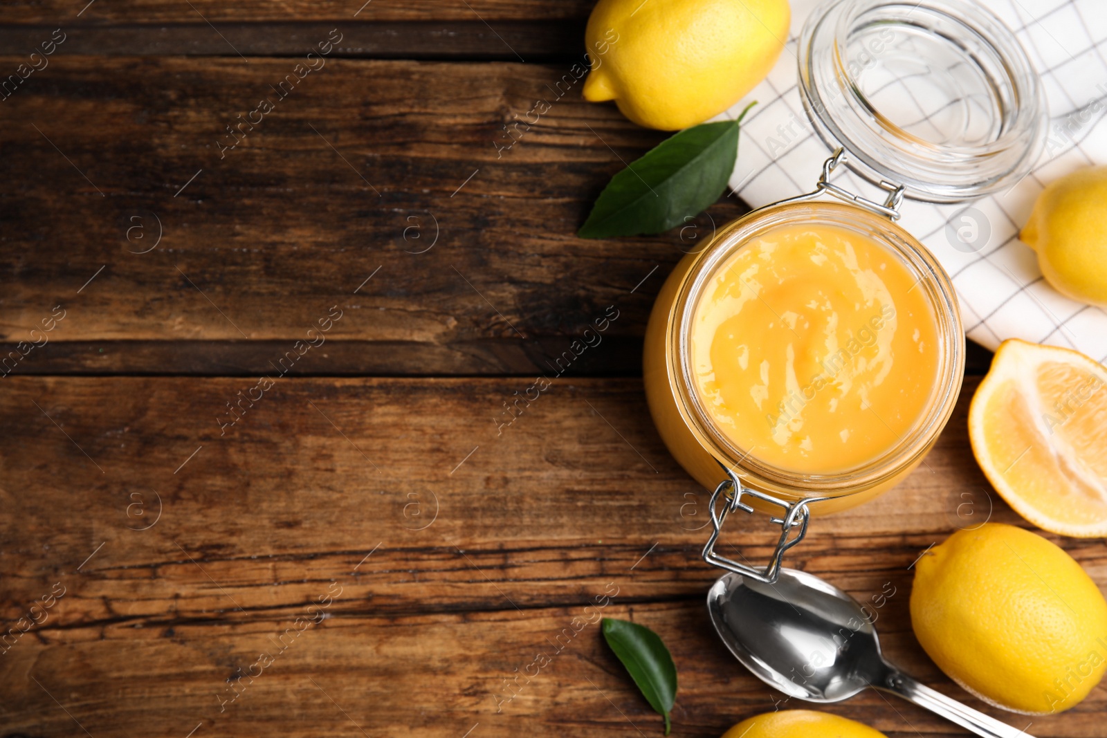 Photo of Delicious lemon curd and fresh fruits on wooden table, flat lay. Space for text