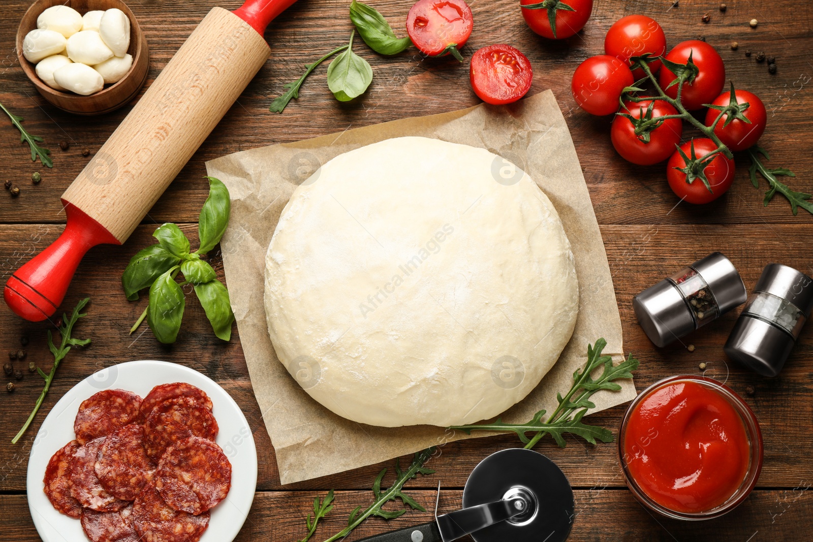 Photo of Flat lay composition with dough and fresh ingredients for pepperoni pizza on wooden table