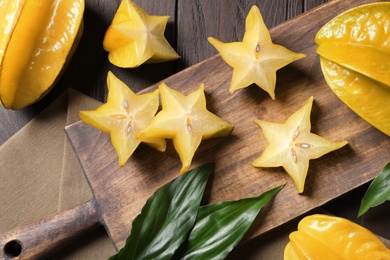 Photo of Delicious carambola fruits on wooden table, flat lay