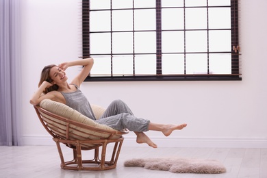 Photo of Young woman relaxing near window with blinds at home. Space for text