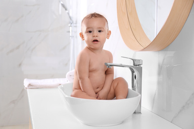 Cute little baby playing in bathroom at home