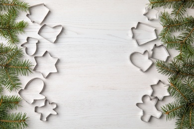 Photo of Flat lay composition with cutters for Christmas cookies on wooden background