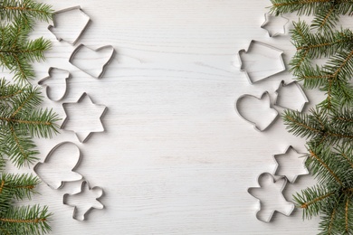 Flat lay composition with cutters for Christmas cookies on wooden background