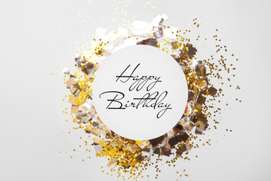 Flat lay composition with greeting HAPPY BIRTHDAY and confetti on white background