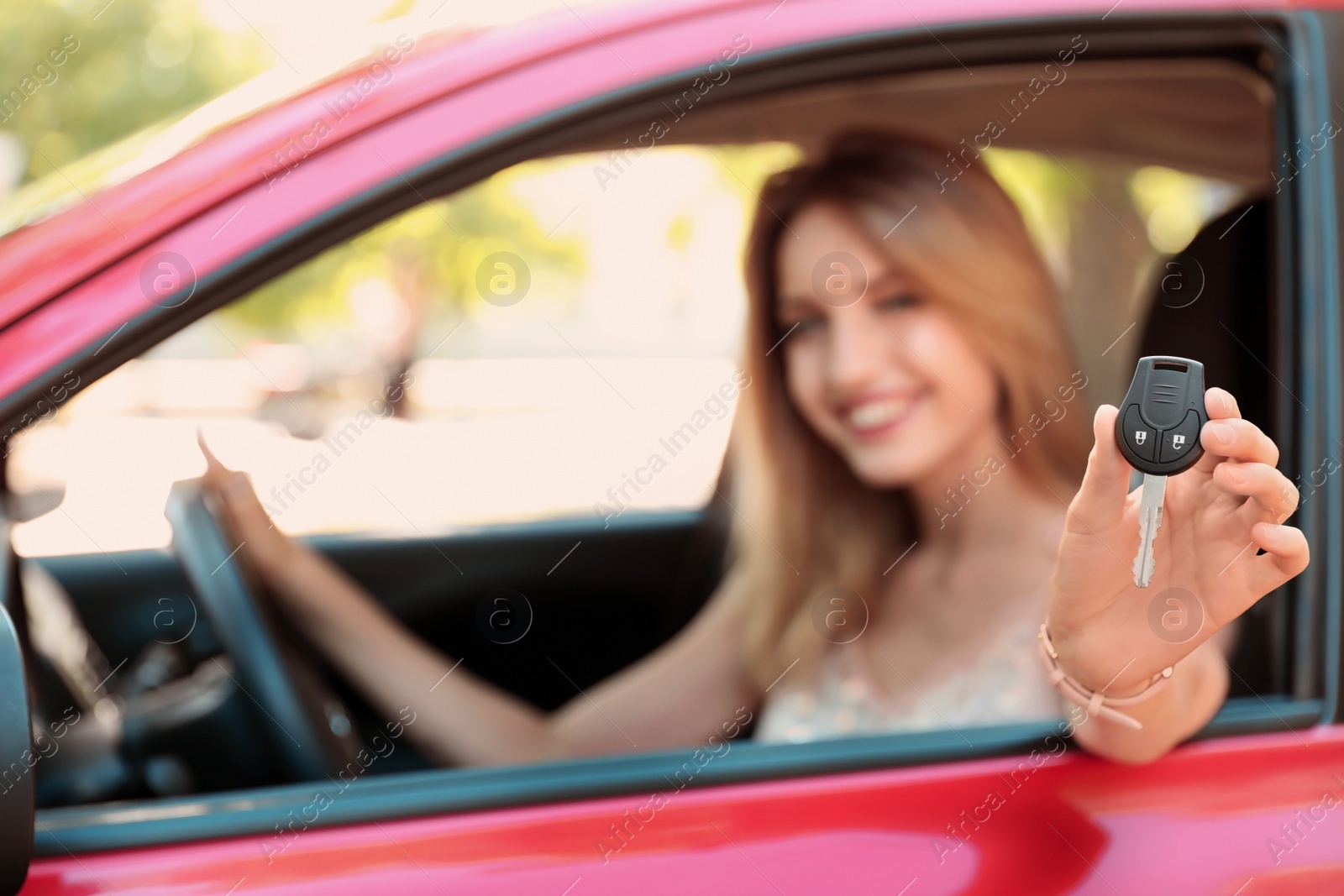 Photo of Beautiful young woman with key sitting in car