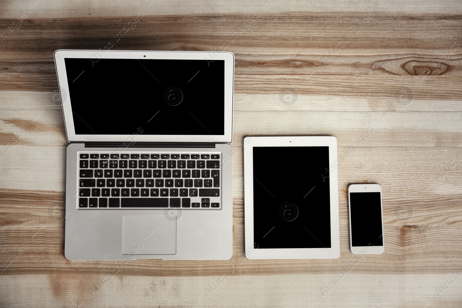 Photo of Devices with blank screens on wooden background, top view. Mock up for design