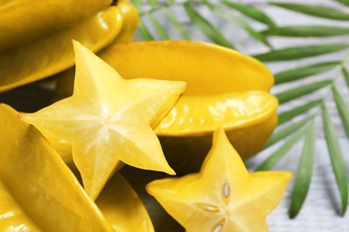 Delicious carambola fruits on light grey table, closeup