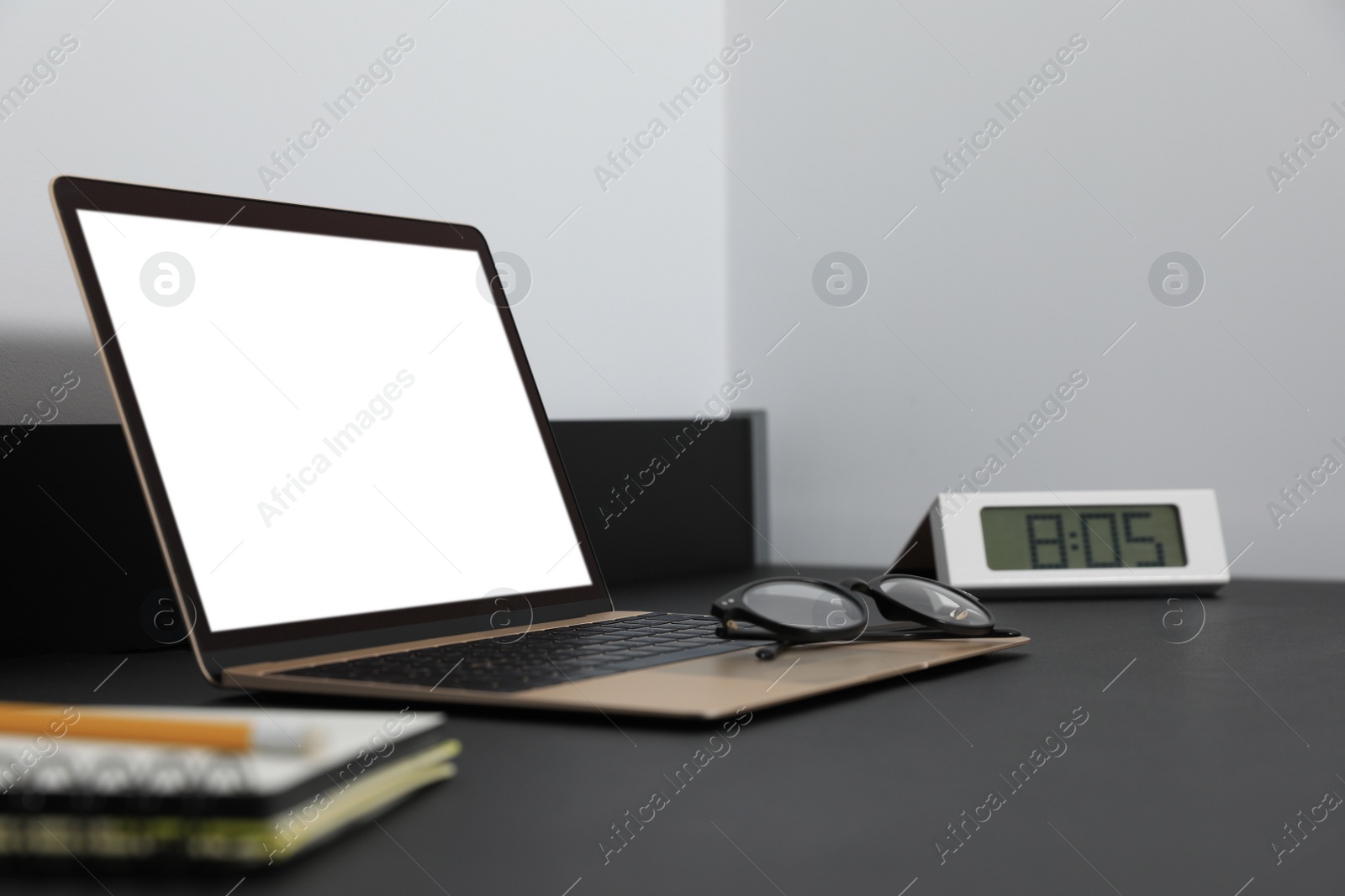 Photo of Modern laptop with blank screen on black table indoors, closeup. Mockup for design