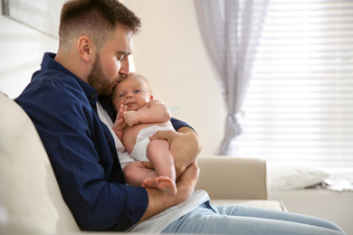 Photo of Father with his newborn son at home. Space for text