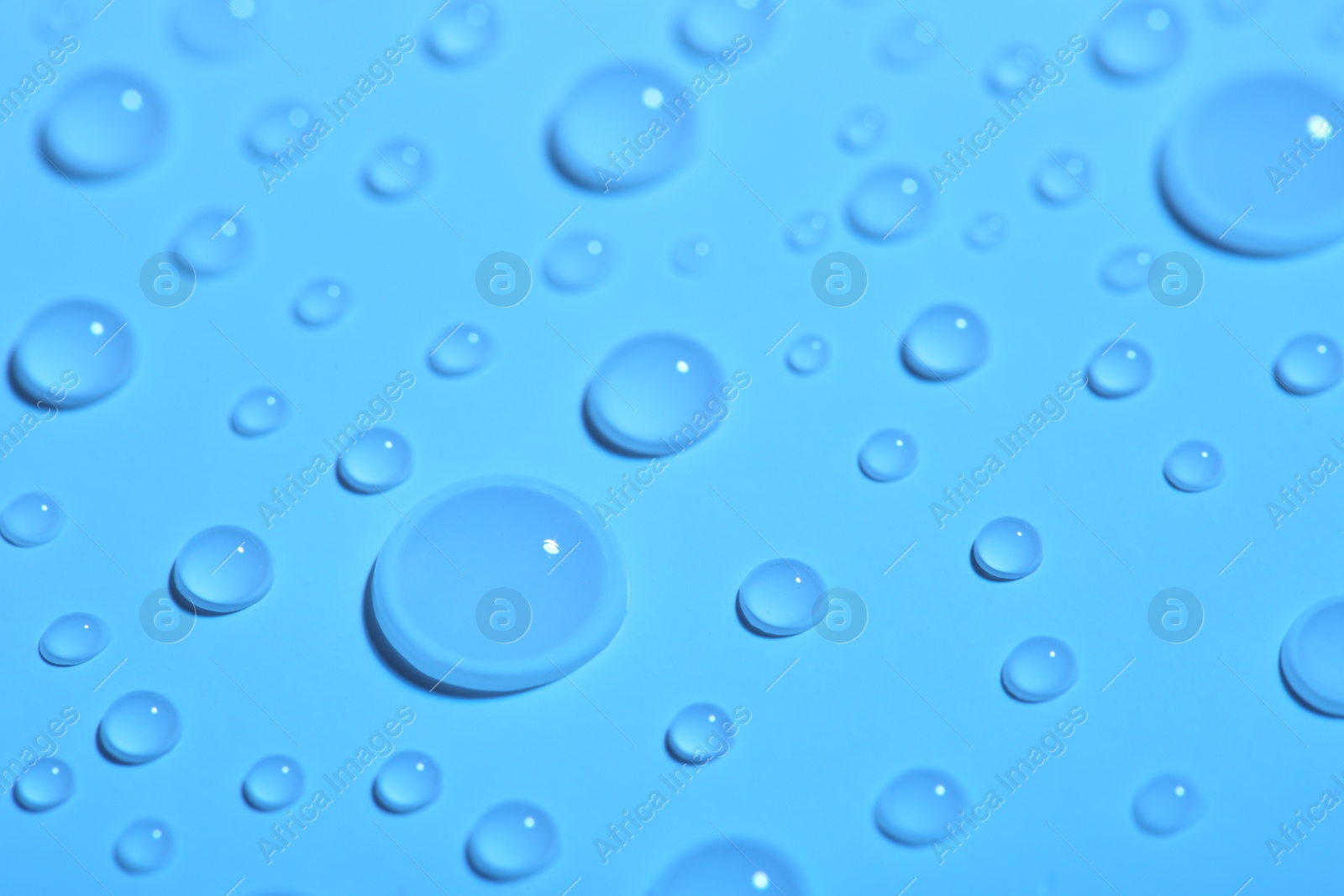 Photo of Pure water drops on color background, closeup