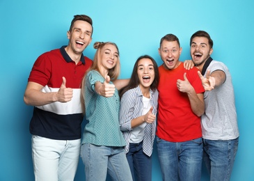 Group of friends celebrating victory against color background
