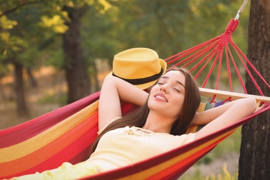 Photo of Young woman resting in comfortable hammock at green garden