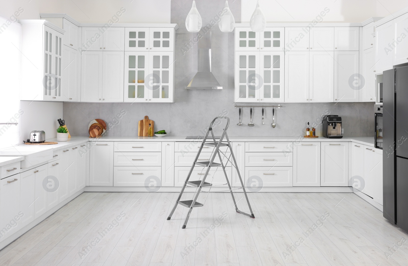 Photo of New metal stepladder on floor in kitchen